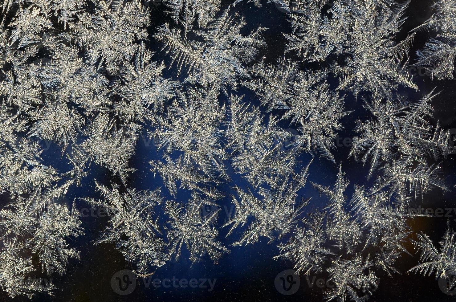 Snowflakes frost rime macro on window glass pane photo