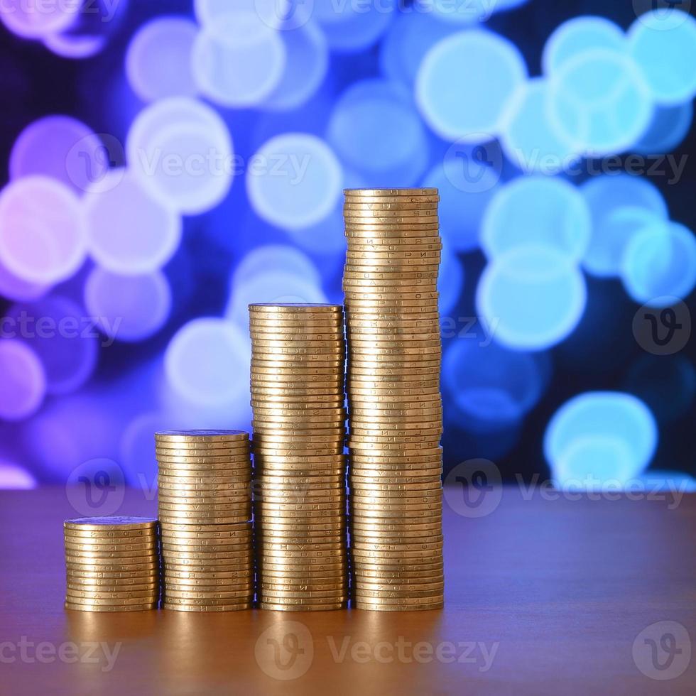Golden coin stacks arranged as a graph. Increasing columns of coins photo