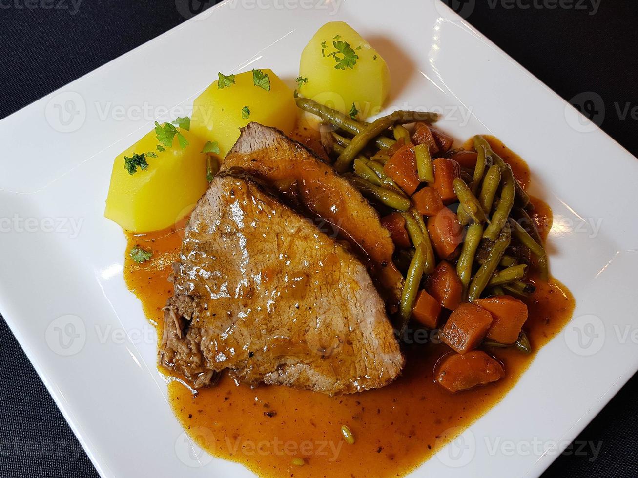 traditional german cuisine a beef pot roast  with vegetables and potatoes photo