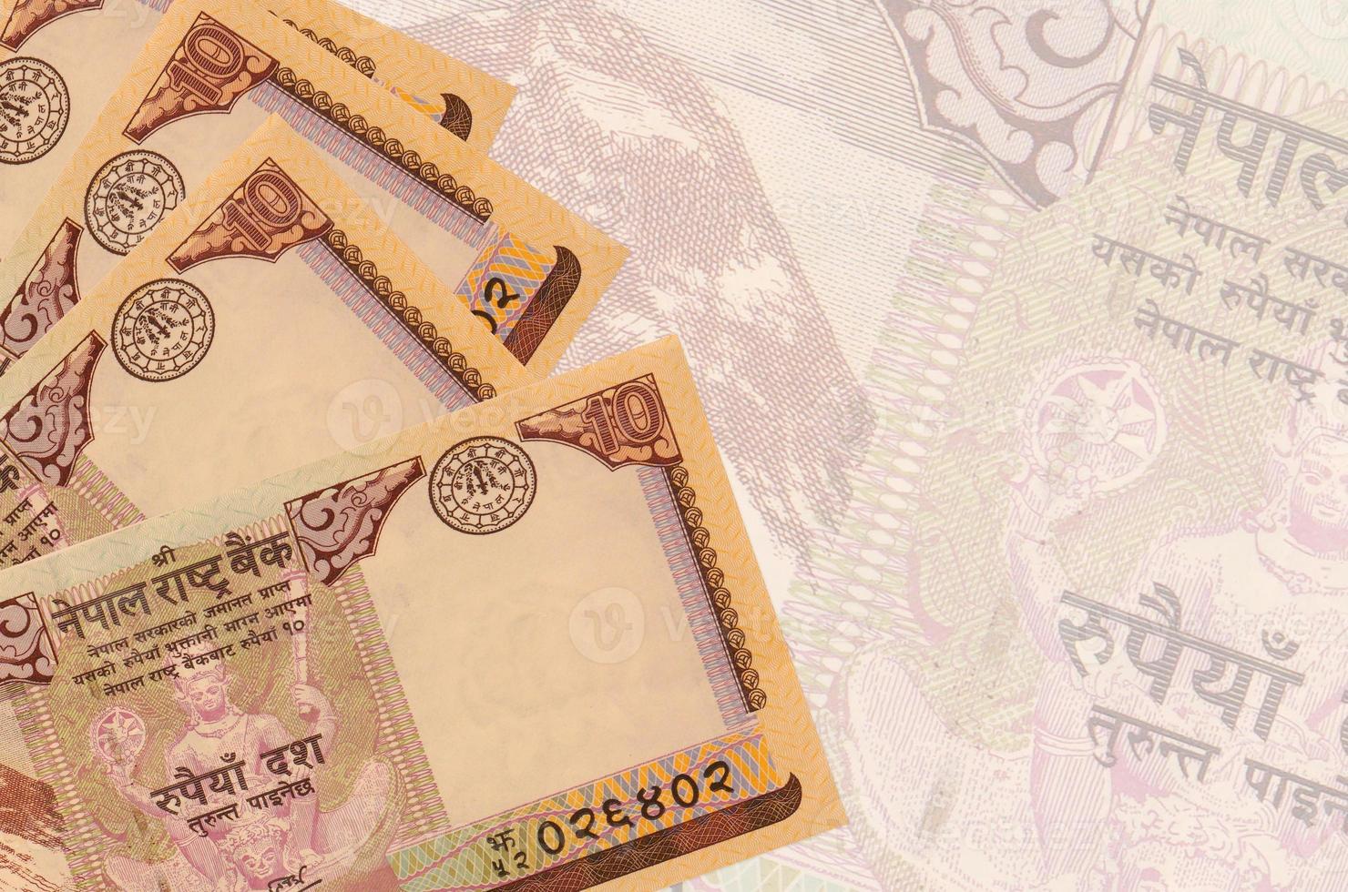 10 Nepalese rupees bills lies in stack on background of big semi-transparent banknote. Abstract business background photo