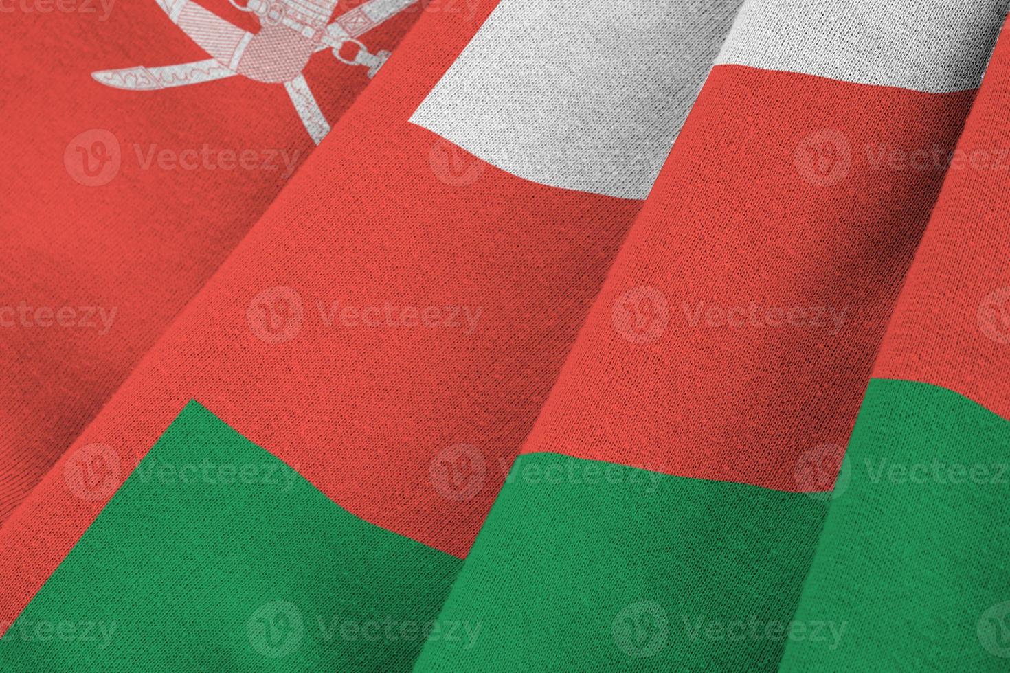 Oman flag with big folds waving close up under the studio light indoors. The official symbols and colors in banner photo