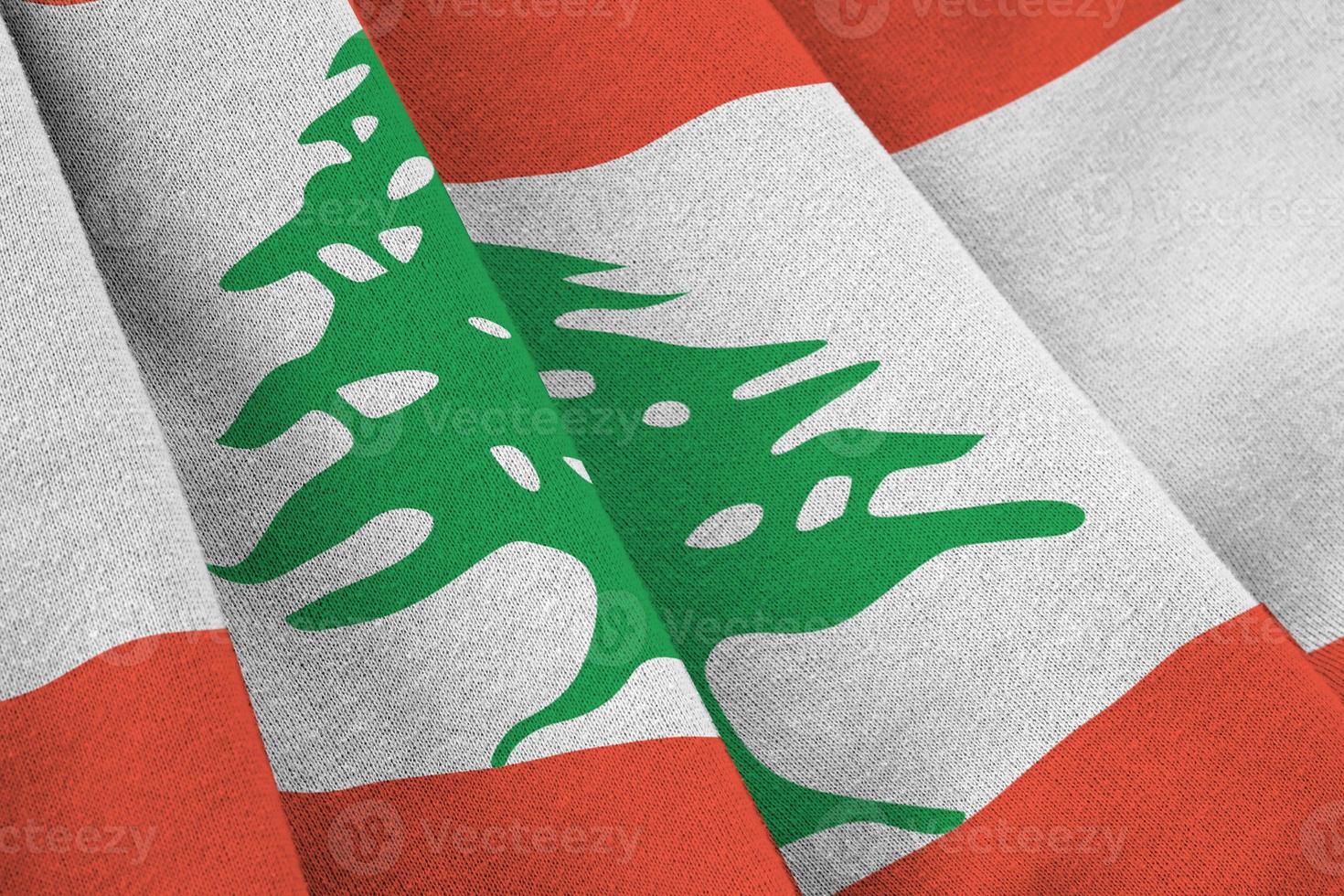 Lebanon flag with big folds waving close up under the studio light indoors. The official symbols and colors in banner photo