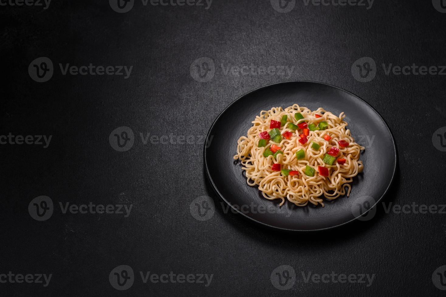 Delicious fresh noodles with sweet pepper, tomato, spices and herbs photo