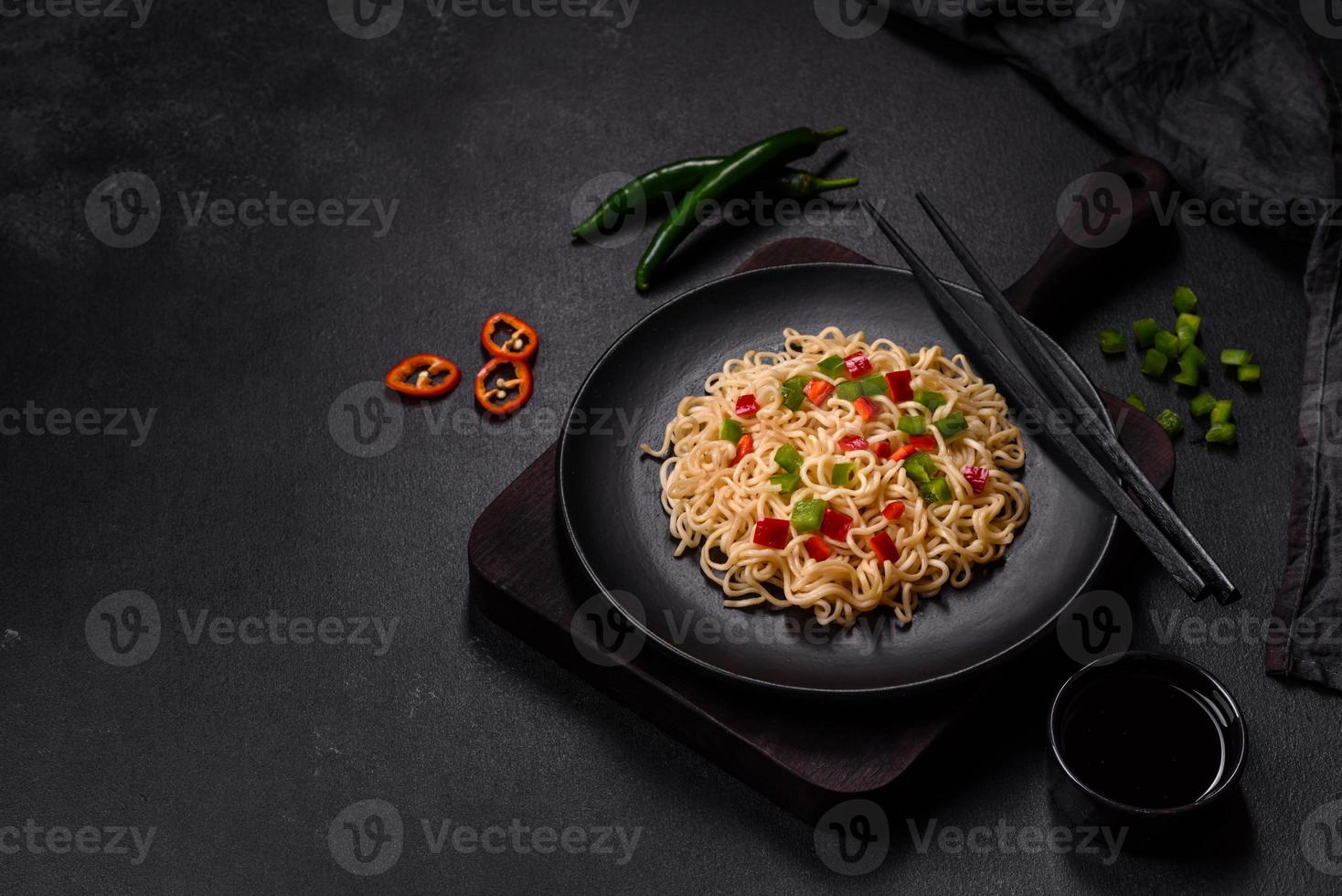 Delicious fresh noodles with sweet pepper, tomato, spices and herbs photo