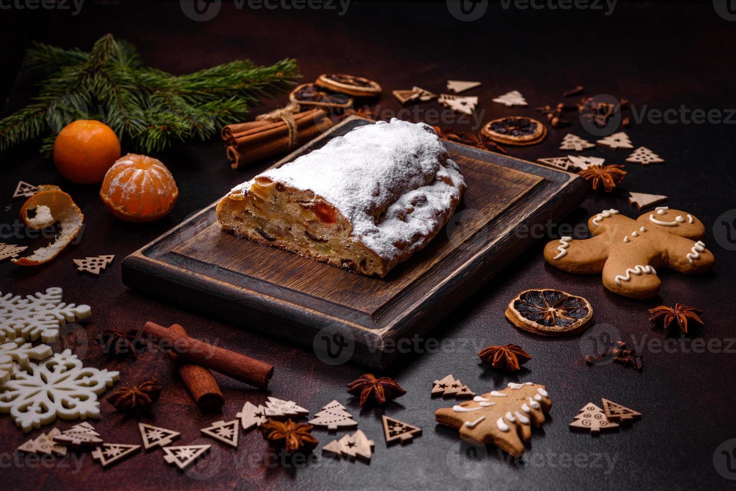 Christmas pie stollen with marzipan, berries and nuts on a dark concrete background photo