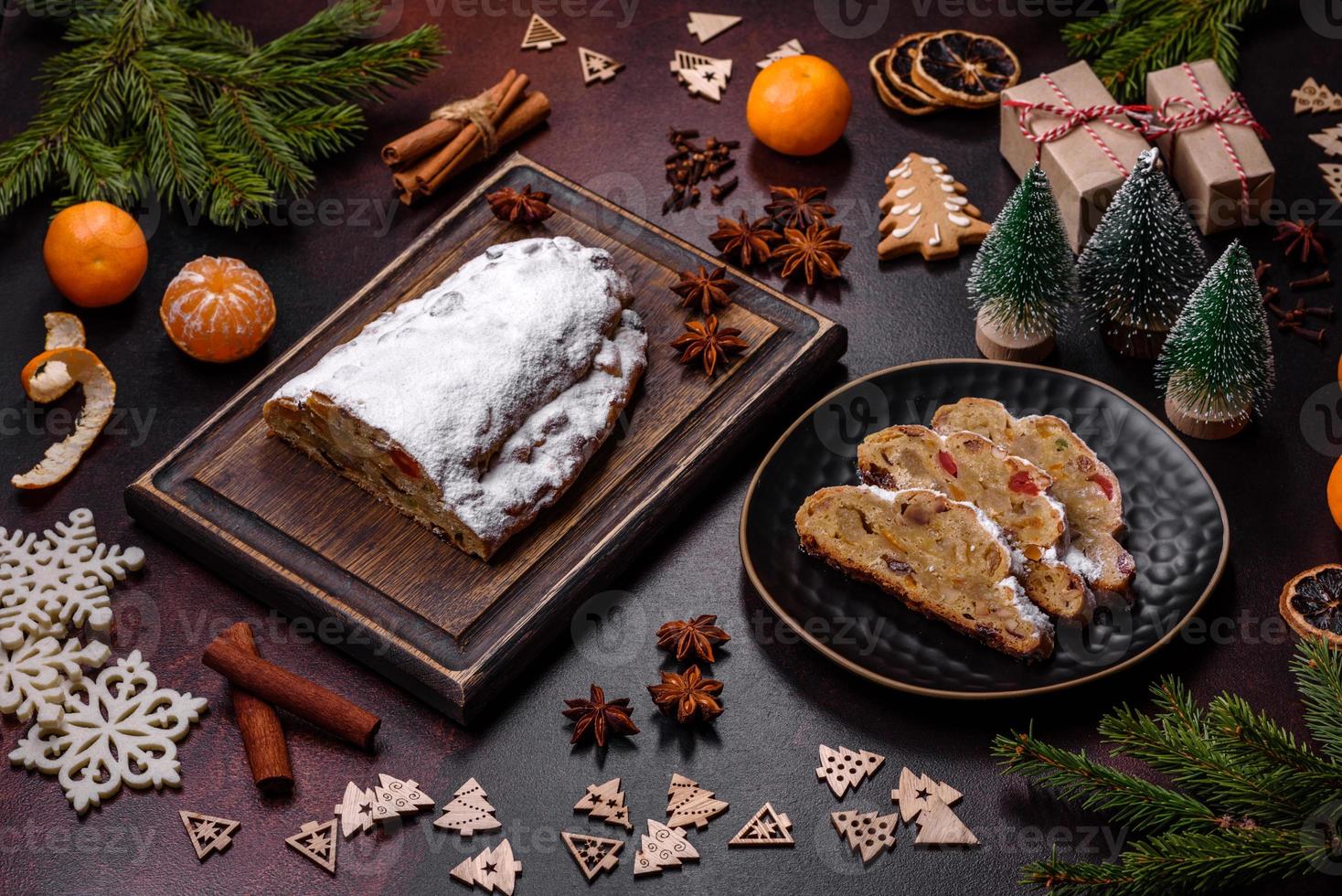 Christmas pie stollen with marzipan, berries and nuts on a dark concrete background photo