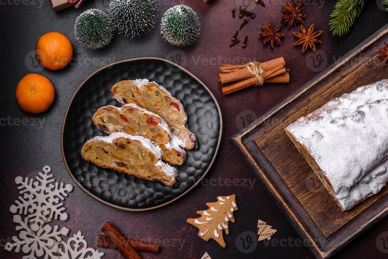 Christmas pie stollen with marzipan, berries and nuts on a dark concrete background photo