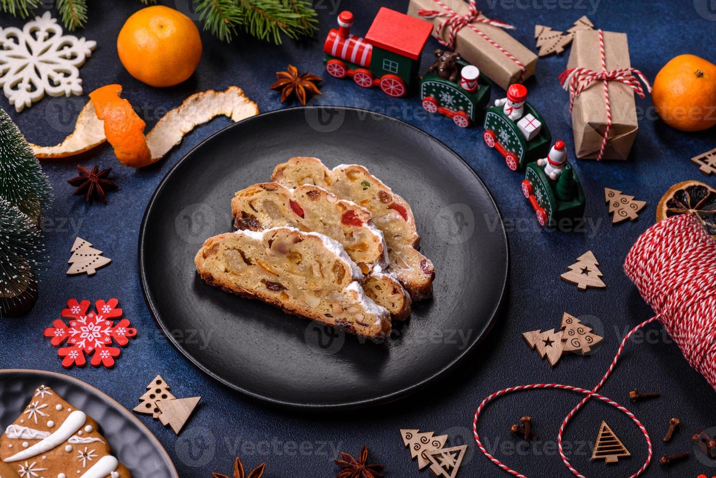 Delicious festive New Year's pie with candied fruits, marzipan and nuts on a dark concrete background photo