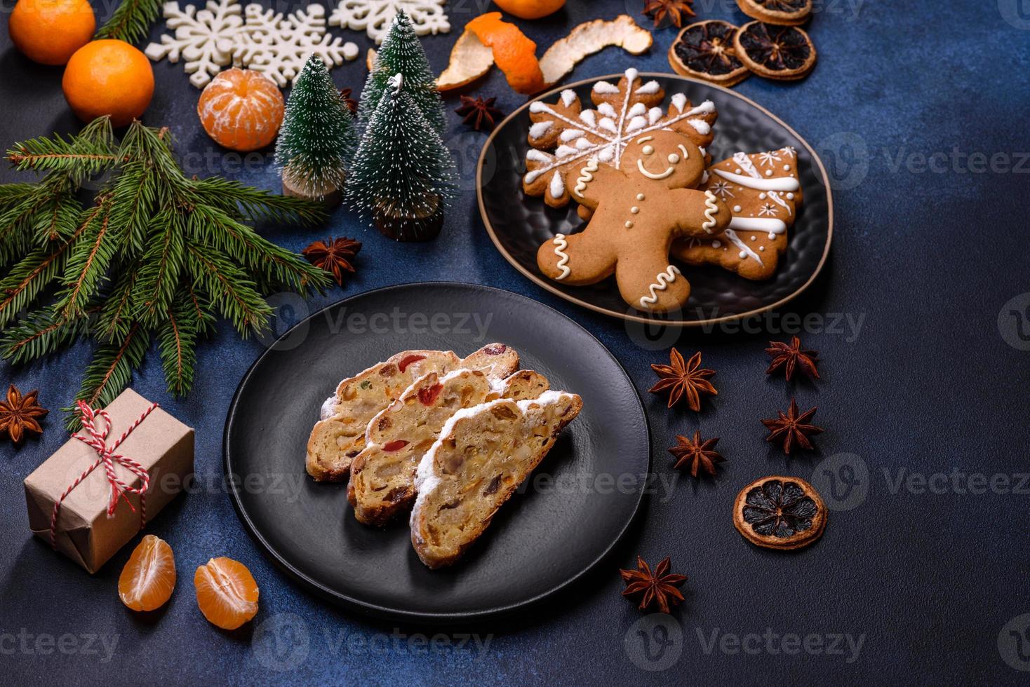 delicioso pastel festivo de año nuevo con frutas confitadas, mazapán y nueces sobre un fondo de hormigón oscuro foto