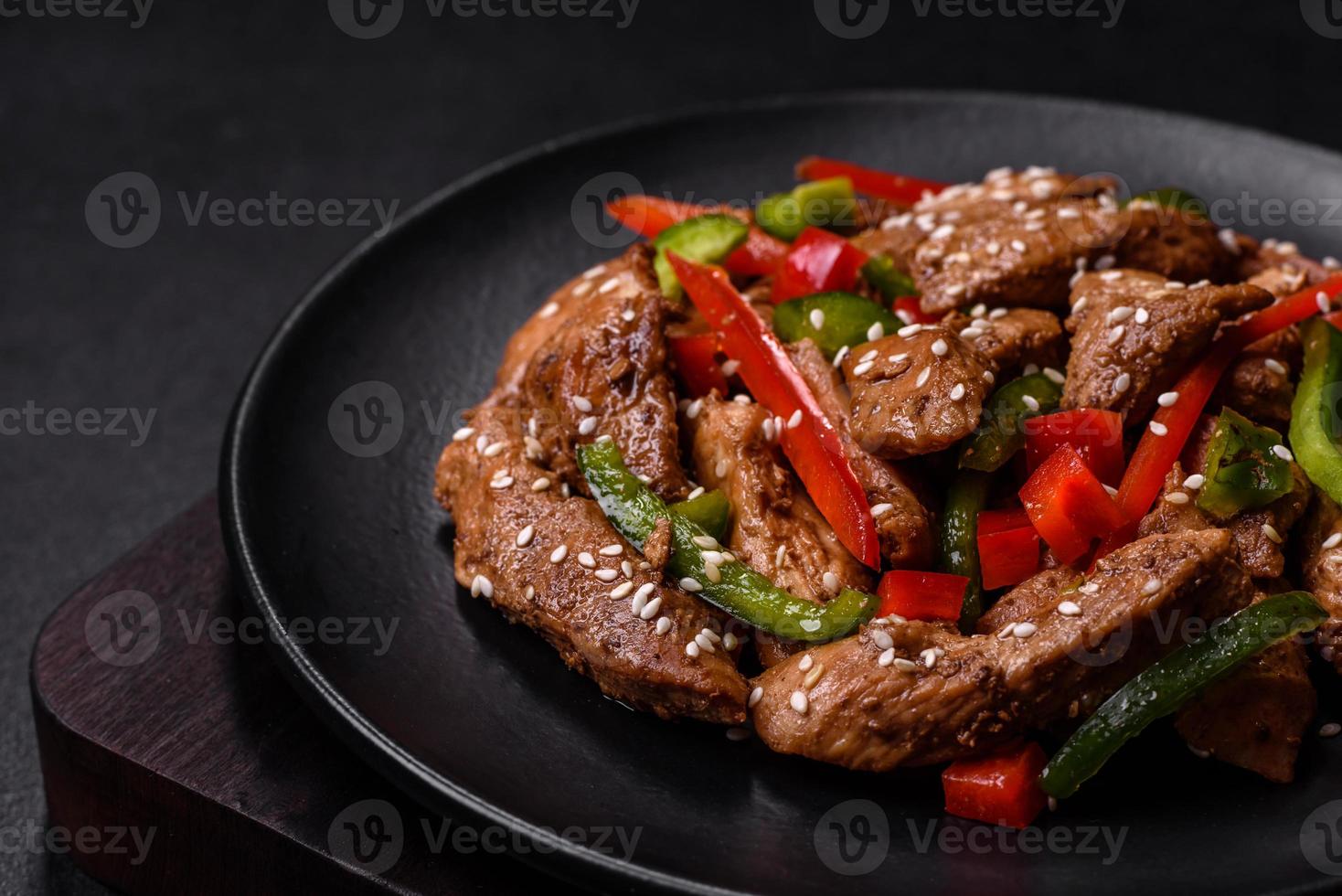 Delicious Asian teriyaki meat with red and green bell peppers photo