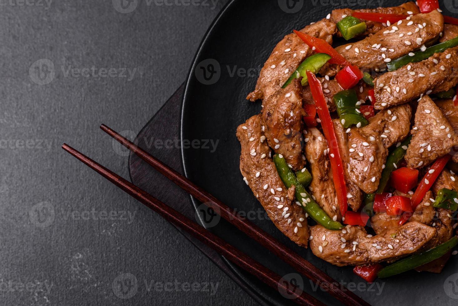 Delicious Asian teriyaki meat with red and green bell peppers photo