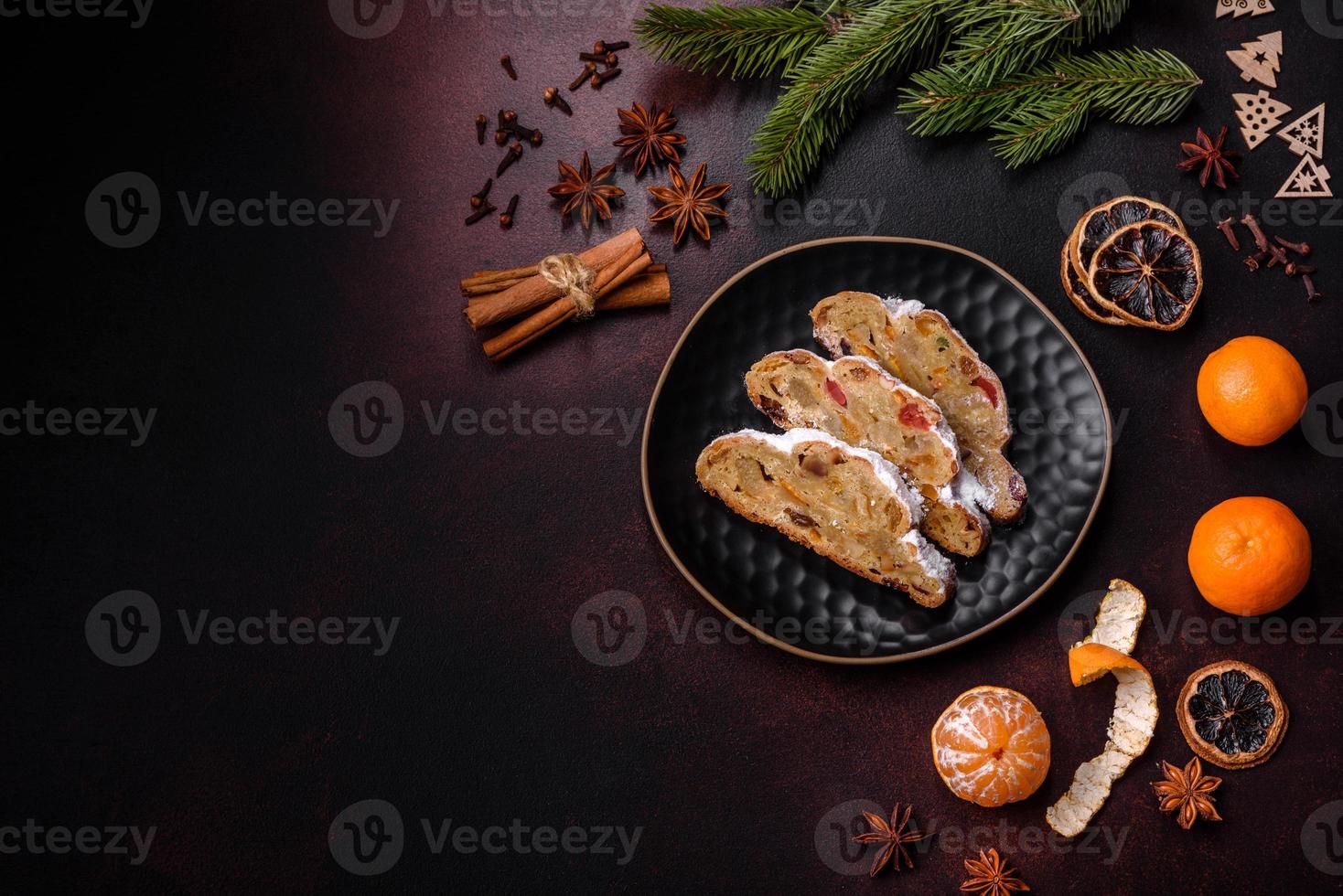 Christmas pie stollen with marzipan, berries and nuts on a dark concrete background photo