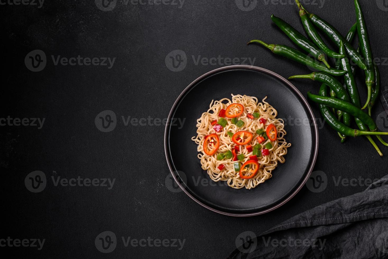 Delicious fresh noodles with sweet pepper, tomato, spices and herbs photo