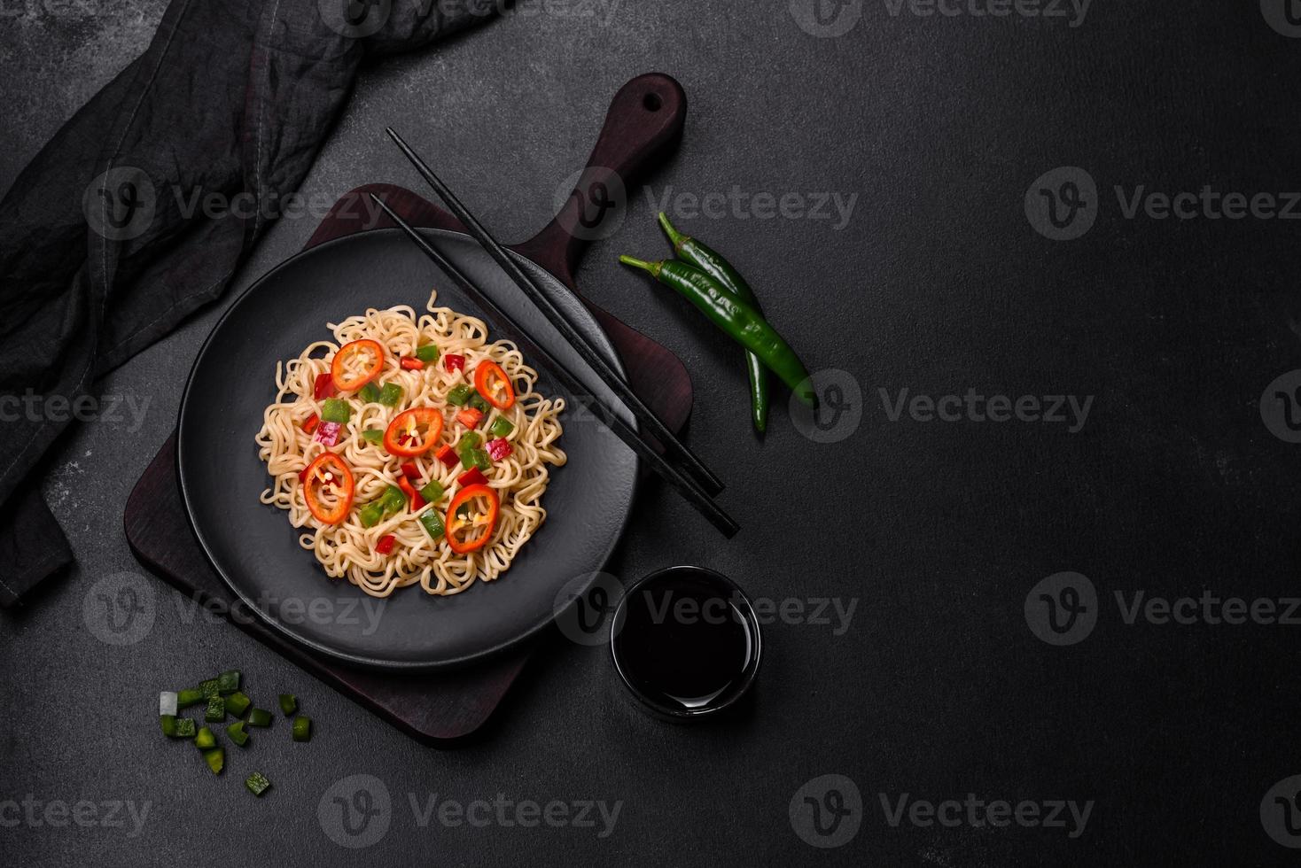 Delicious fresh noodles with sweet pepper, tomato, spices and herbs photo