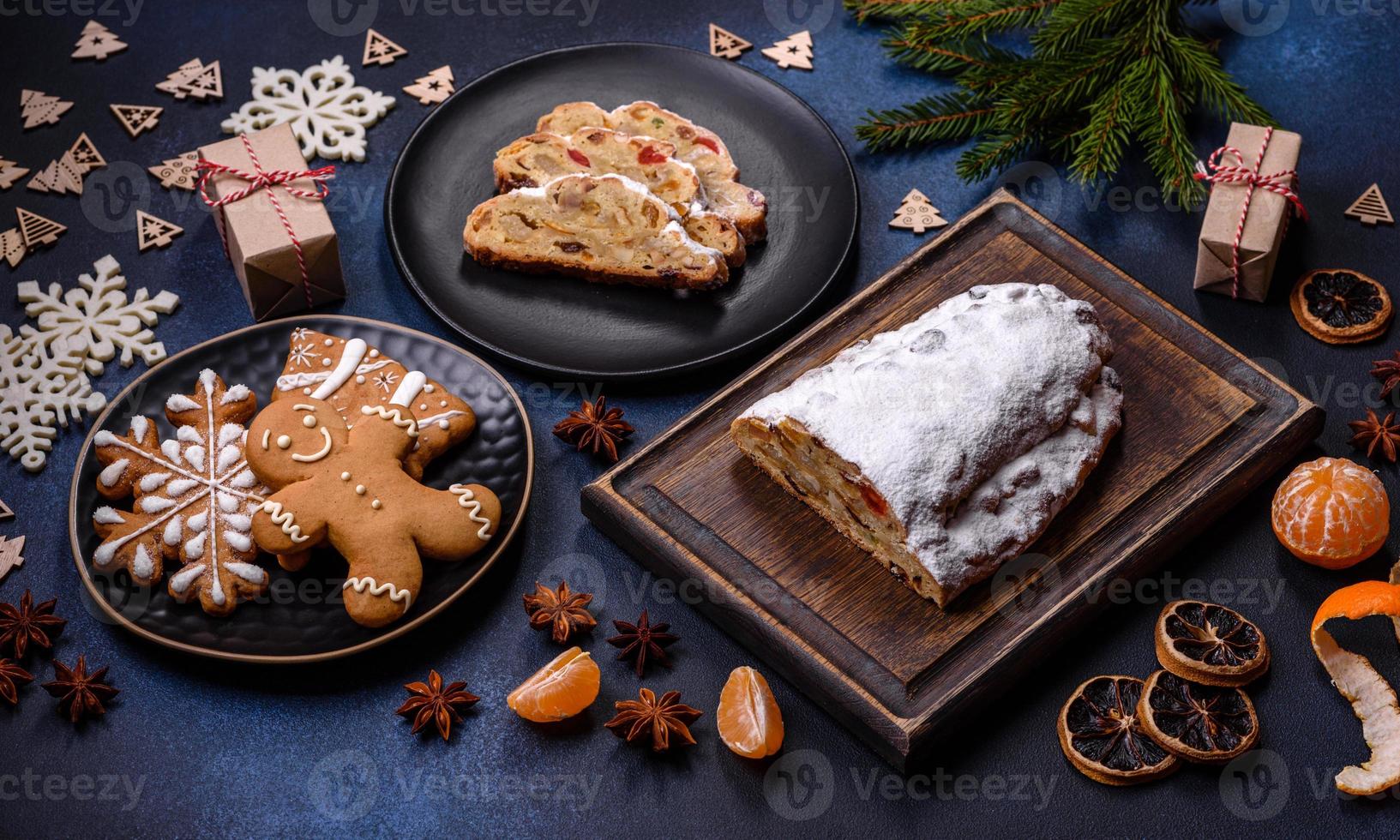 Delicious festive New Year's pie with candied fruits, marzipan and nuts on a dark concrete background photo