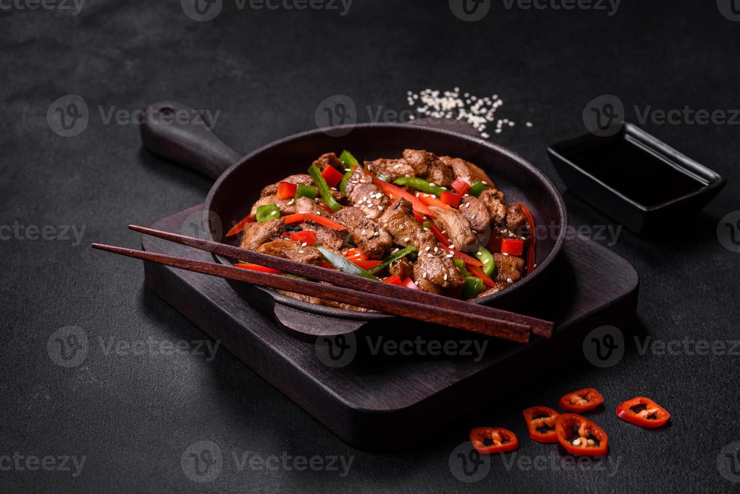 Delicious Asian teriyaki meat with red and green bell peppers photo