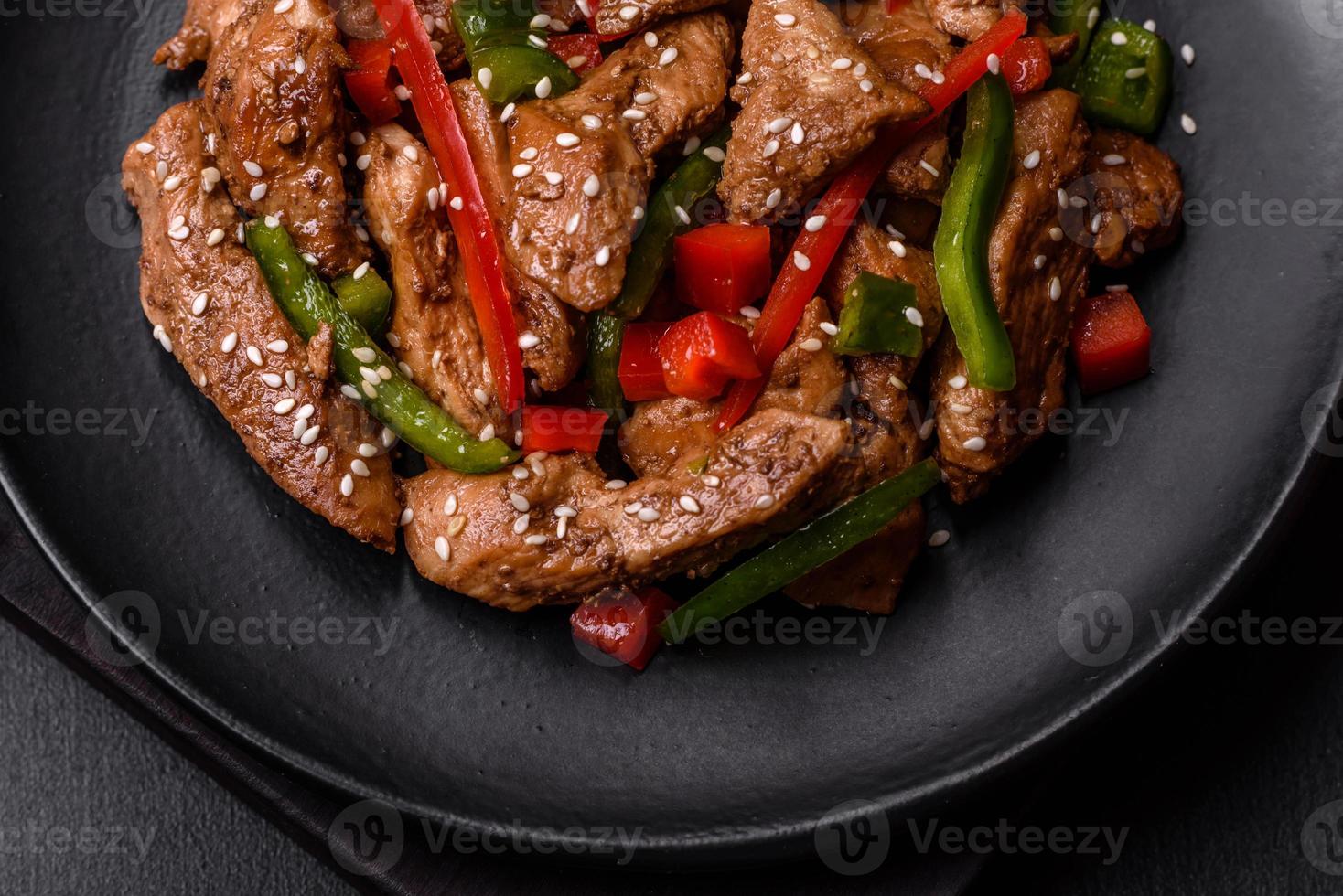 Delicious Asian teriyaki meat with red and green bell peppers photo