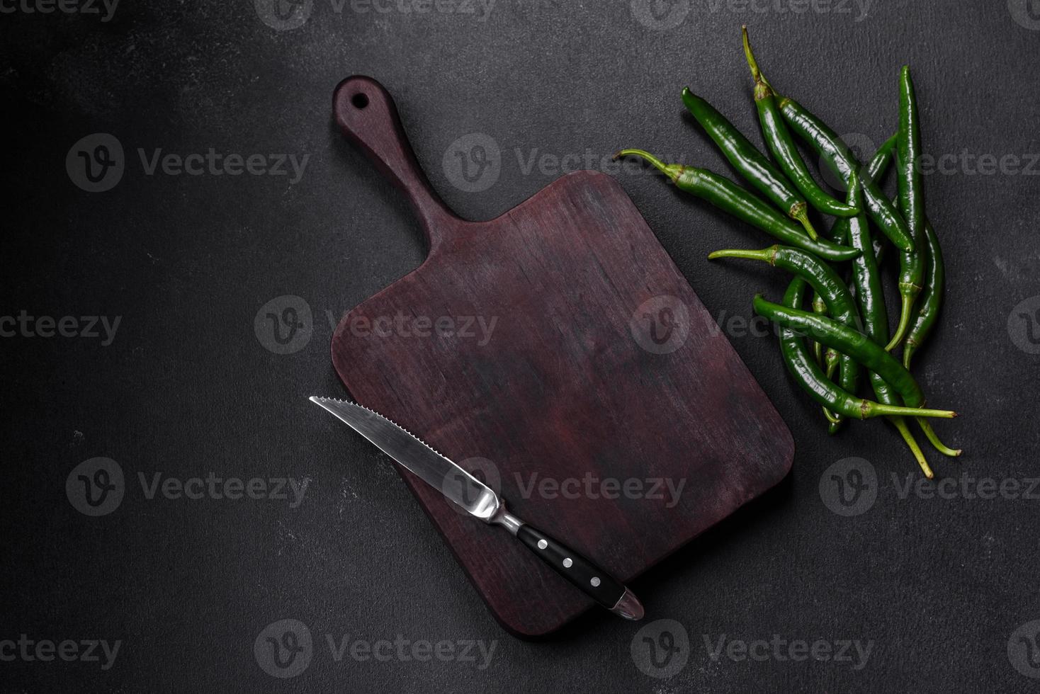 Hot pepper of green color on a dark concrete background photo