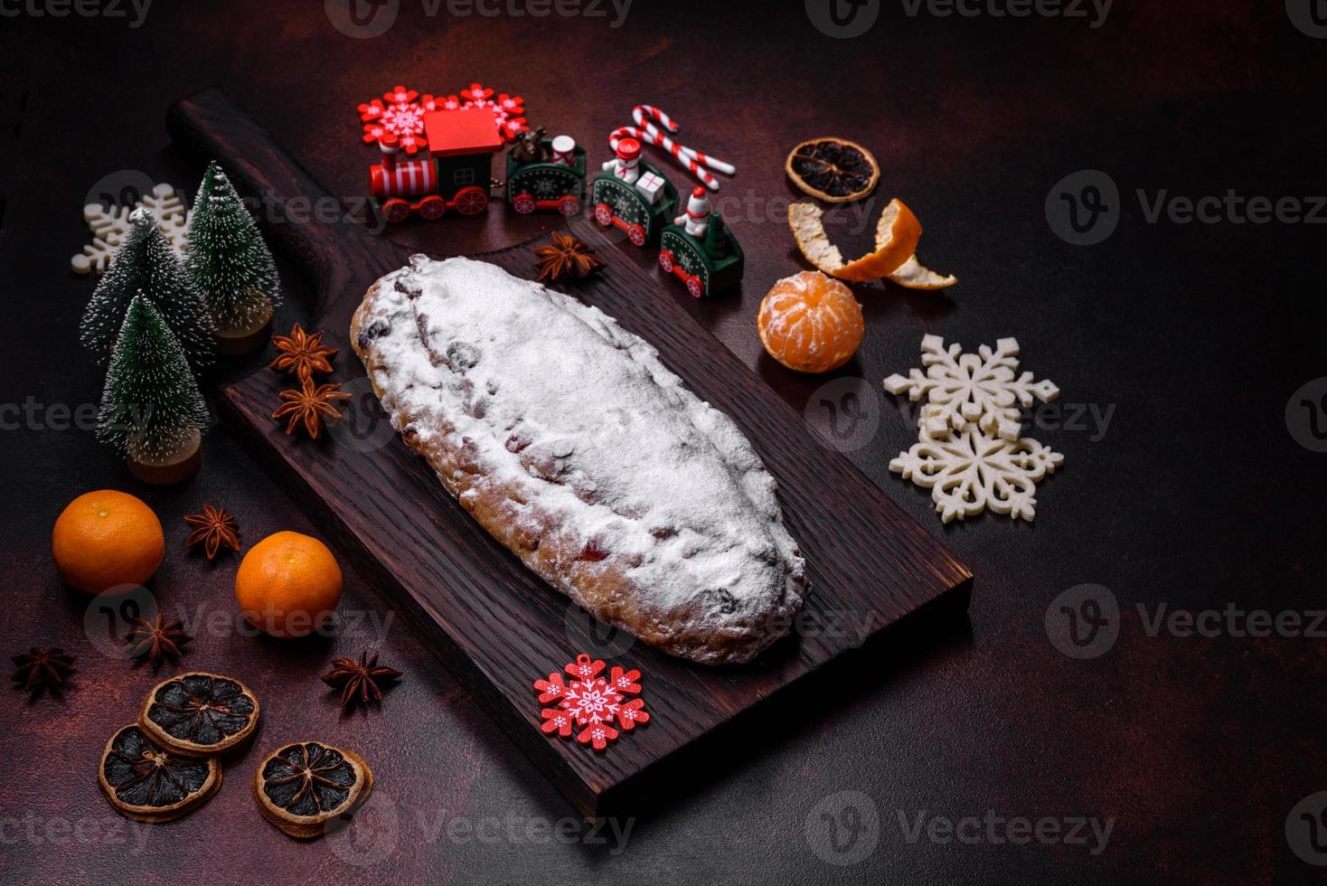 Christmas pie stollen with marzipan, berries and nuts on a dark concrete background photo