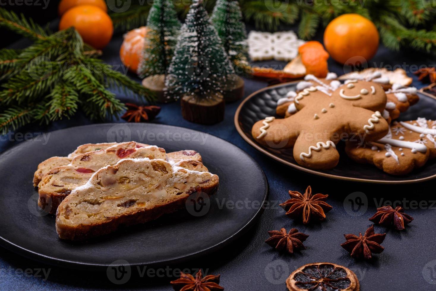 delicioso pastel festivo de año nuevo con frutas confitadas, mazapán y nueces sobre un fondo de hormigón oscuro foto