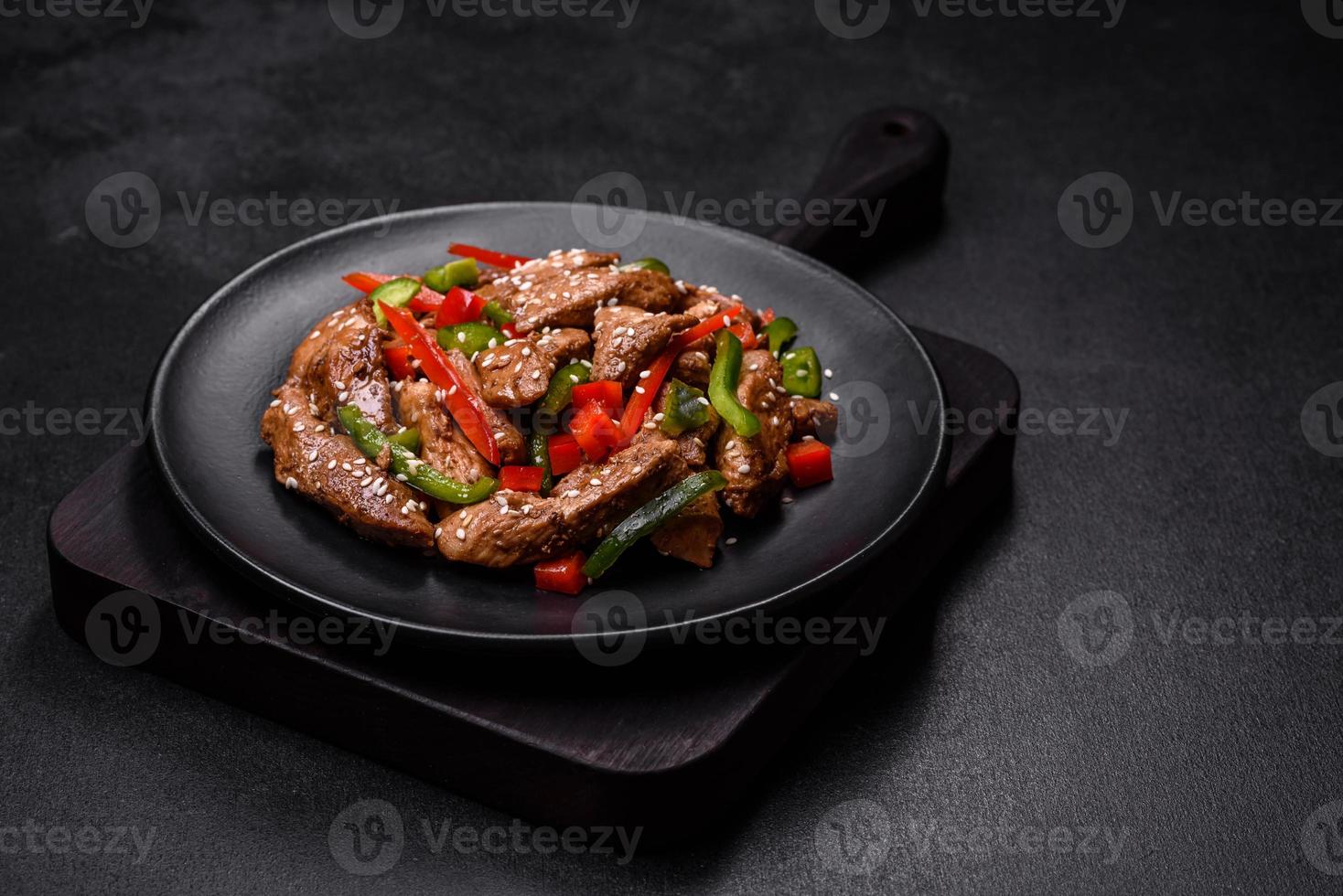 Delicious Asian teriyaki meat with red and green bell peppers photo