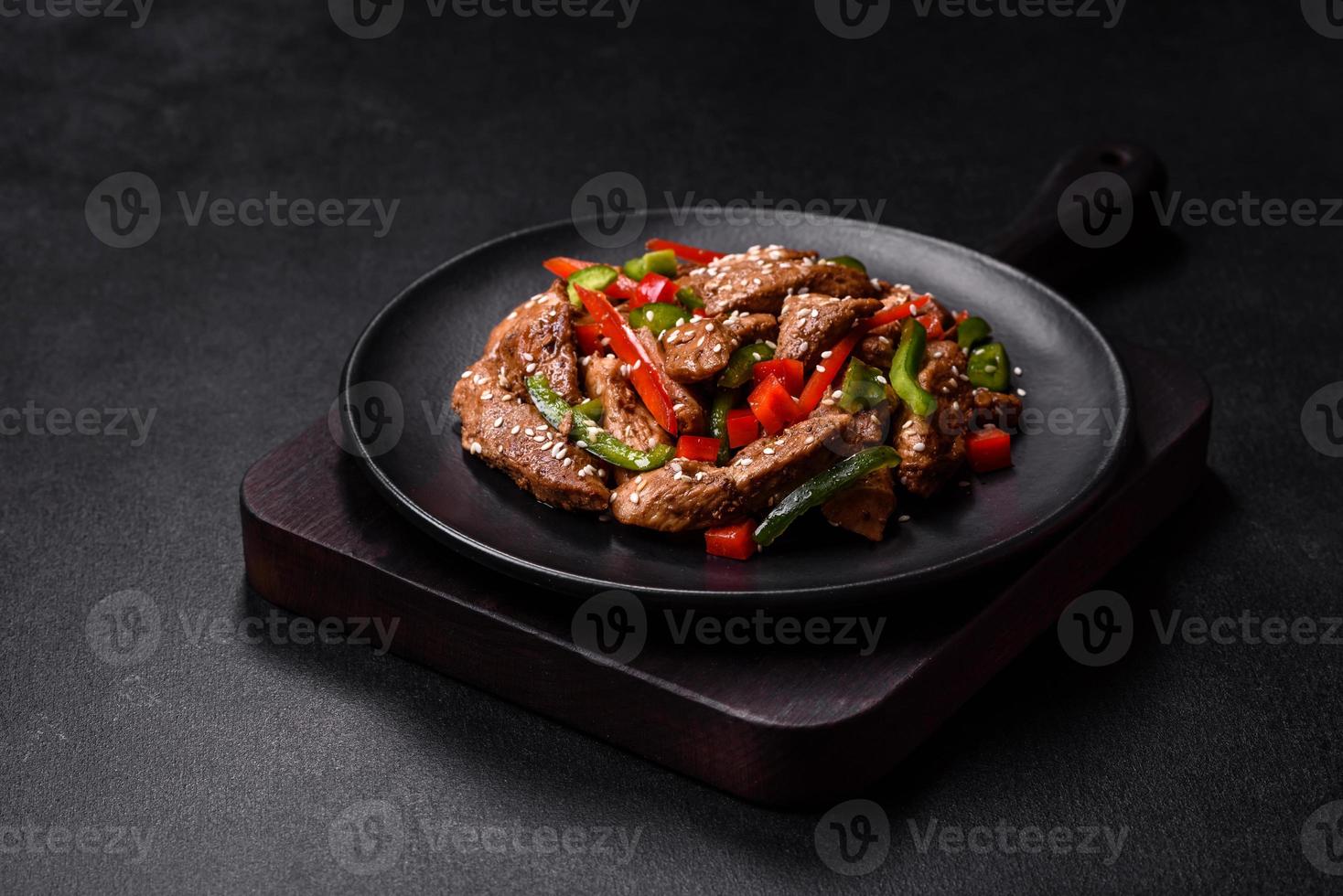 Delicious Asian teriyaki meat with red and green bell peppers photo