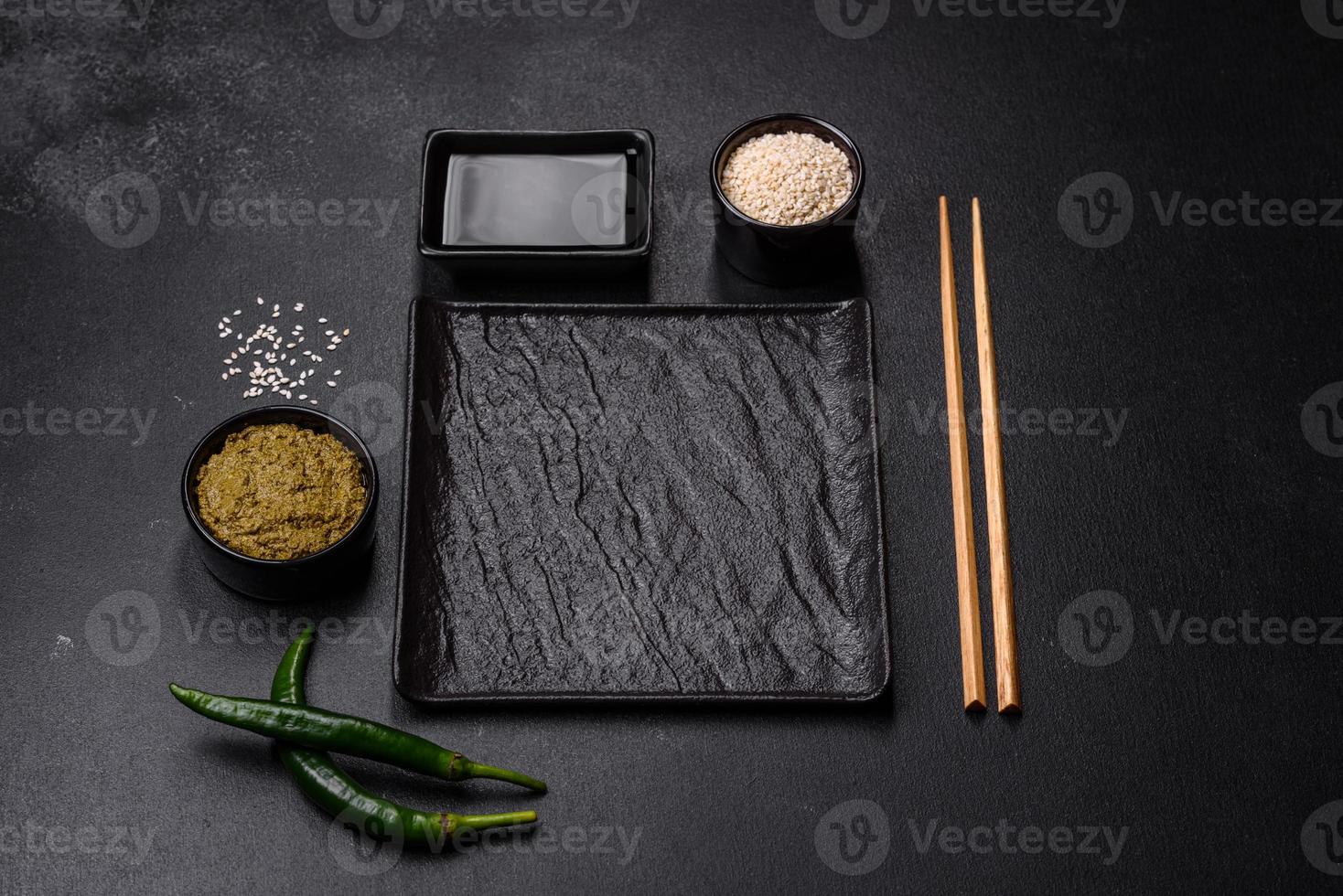 Empty plate with wooden sticks for Asian food on a dark concrete background photo