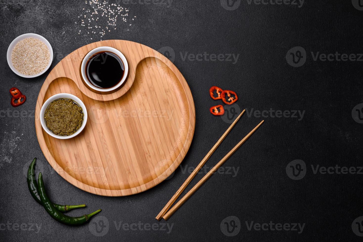 Empty plate with wooden sticks for Asian food on a dark concrete background photo