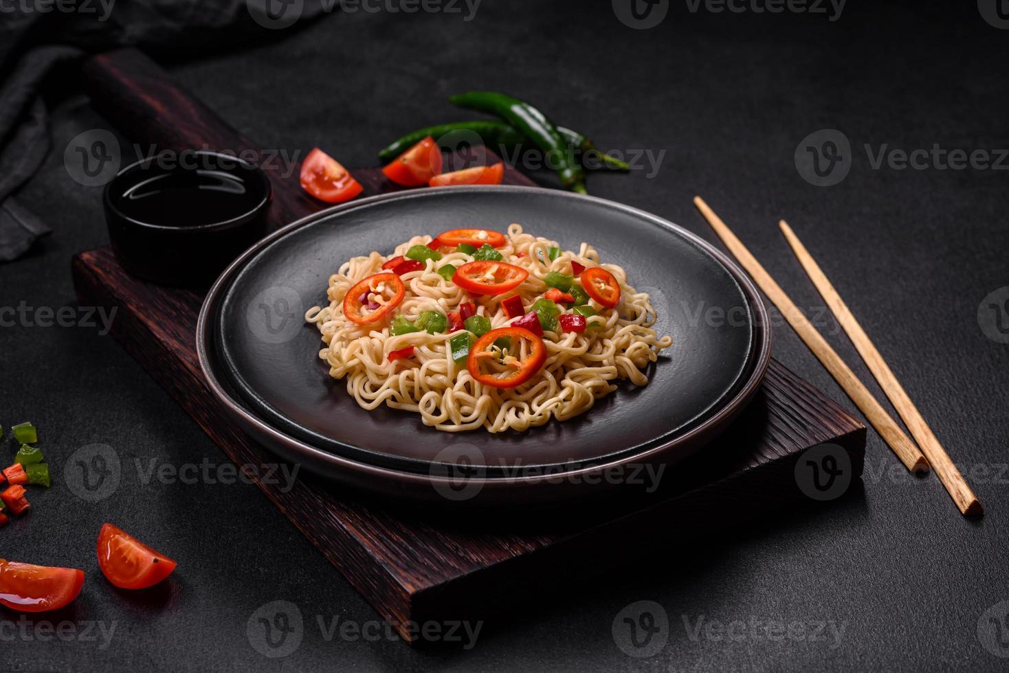 Delicious fresh noodles with sweet pepper, tomato, spices and herbs photo