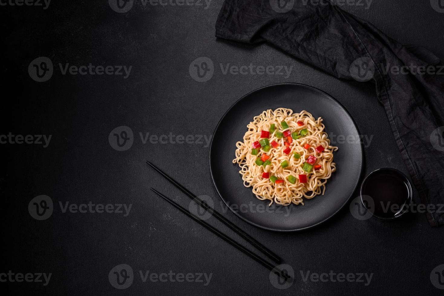 Delicious fresh noodles with sweet pepper, tomato, spices and herbs photo