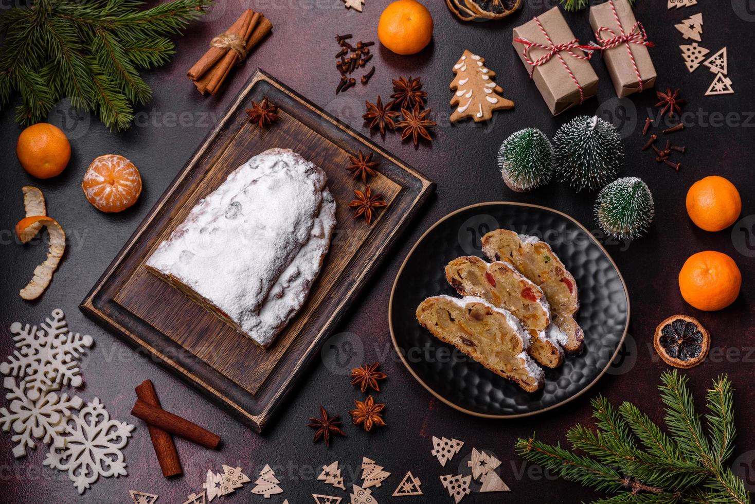 Christmas pie stollen with marzipan, berries and nuts on a dark concrete background photo