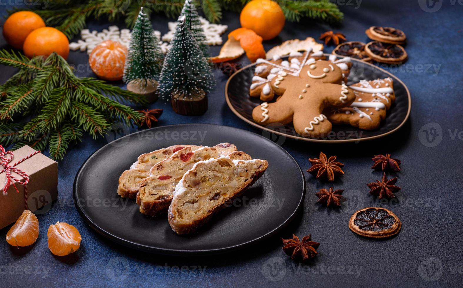 delicioso pastel festivo de año nuevo con frutas confitadas, mazapán y nueces sobre un fondo de hormigón oscuro foto