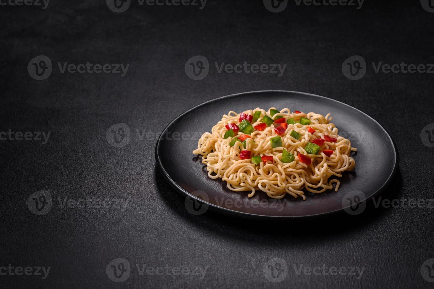 Delicious fresh noodles with sweet pepper, tomato, spices and herbs photo