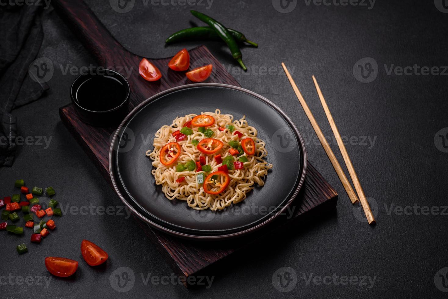 Delicious fresh noodles with sweet pepper, tomato, spices and herbs photo