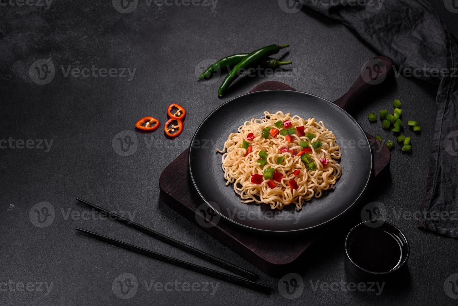 Delicious fresh noodles with sweet pepper, tomato, spices and herbs photo