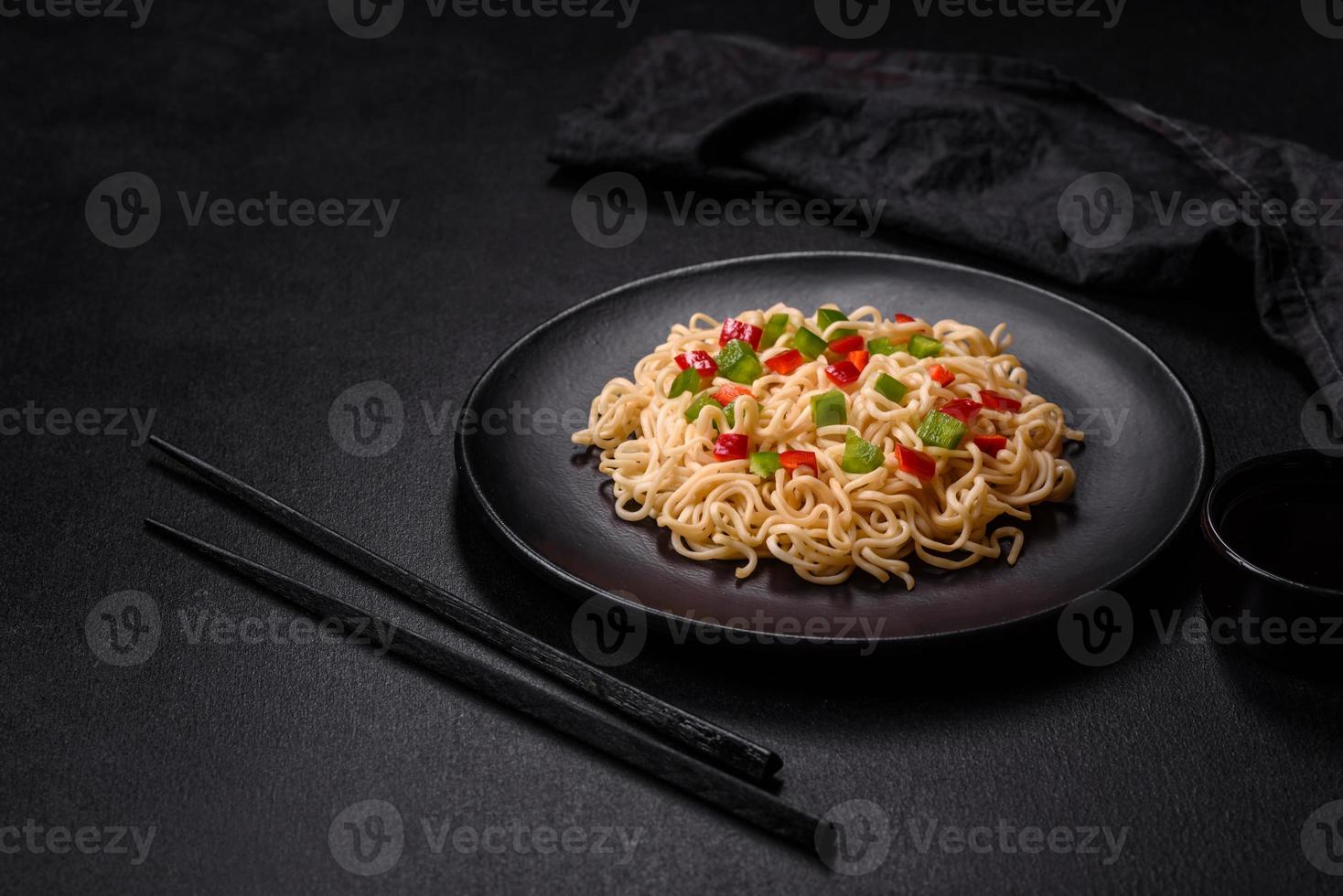 Delicious fresh noodles with sweet pepper, tomato, spices and herbs photo