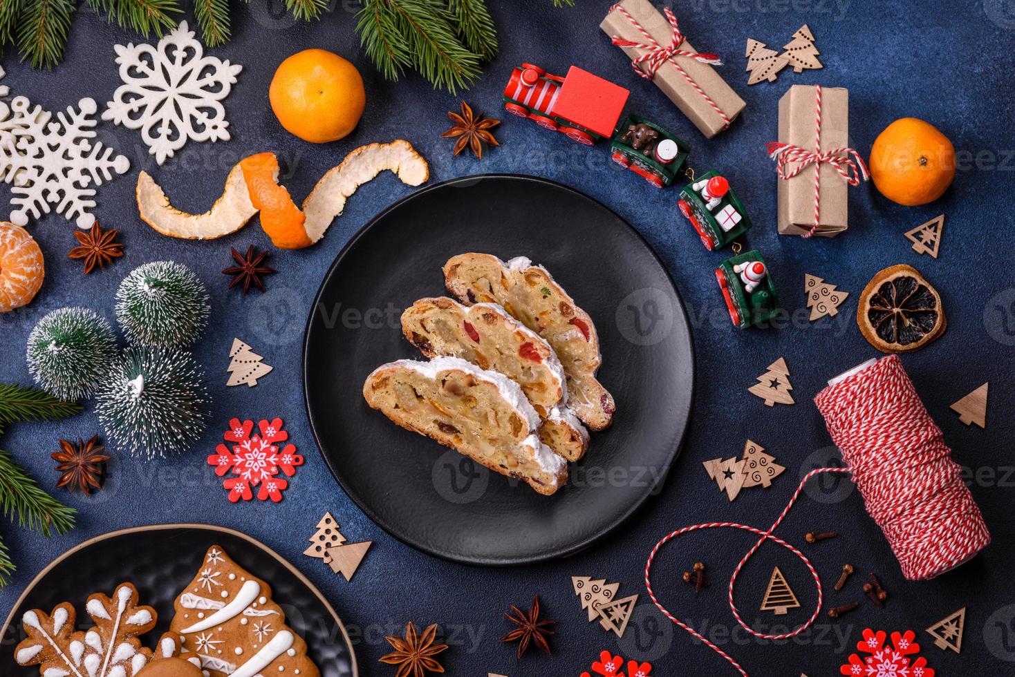 Delicious festive New Year's pie with candied fruits, marzipan and nuts on a dark concrete background photo