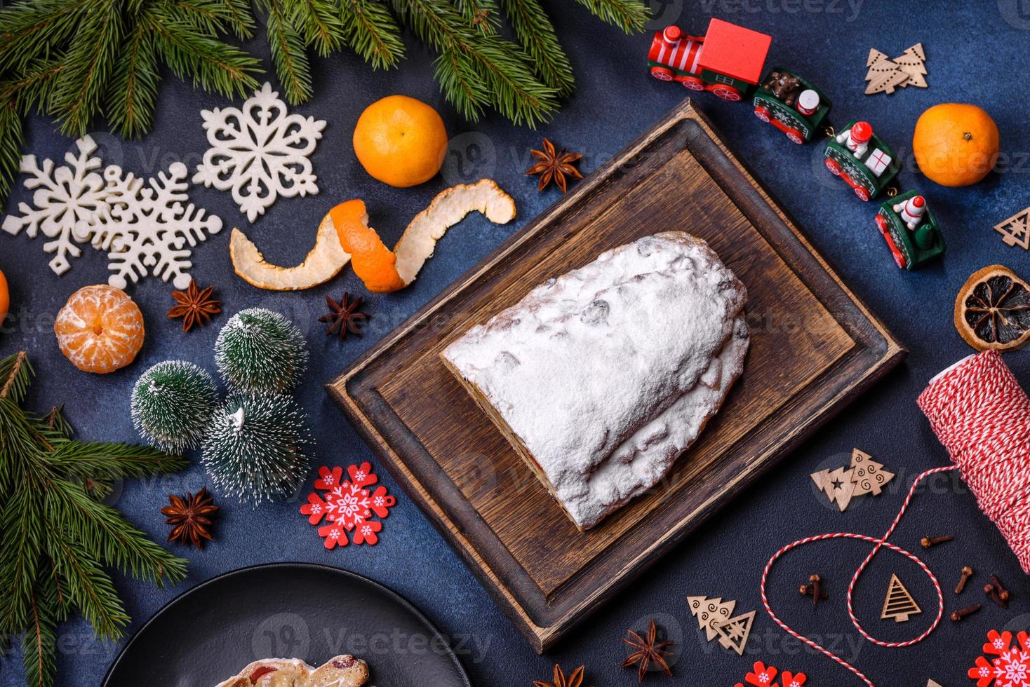 Delicious festive New Year's pie with candied fruits, marzipan and nuts on a dark concrete background photo
