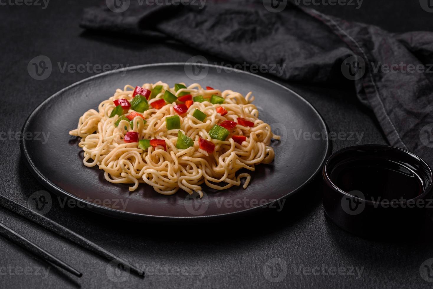 Delicious fresh noodles with sweet pepper, tomato, spices and herbs photo