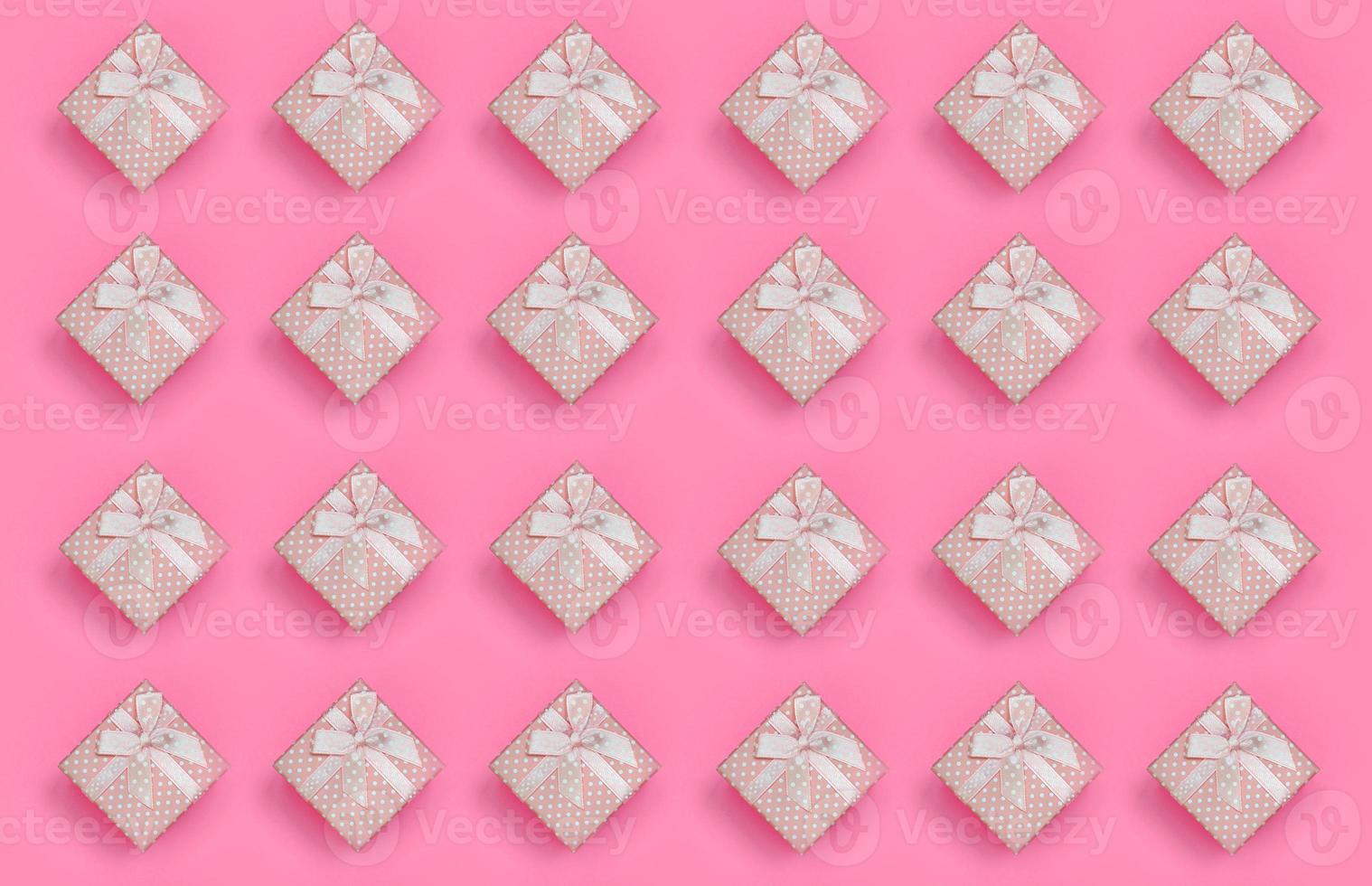 A lot of pink gift boxes lies on texture background of fashion pastel pink color paper in minimal concept. Abstract trendy pattern photo
