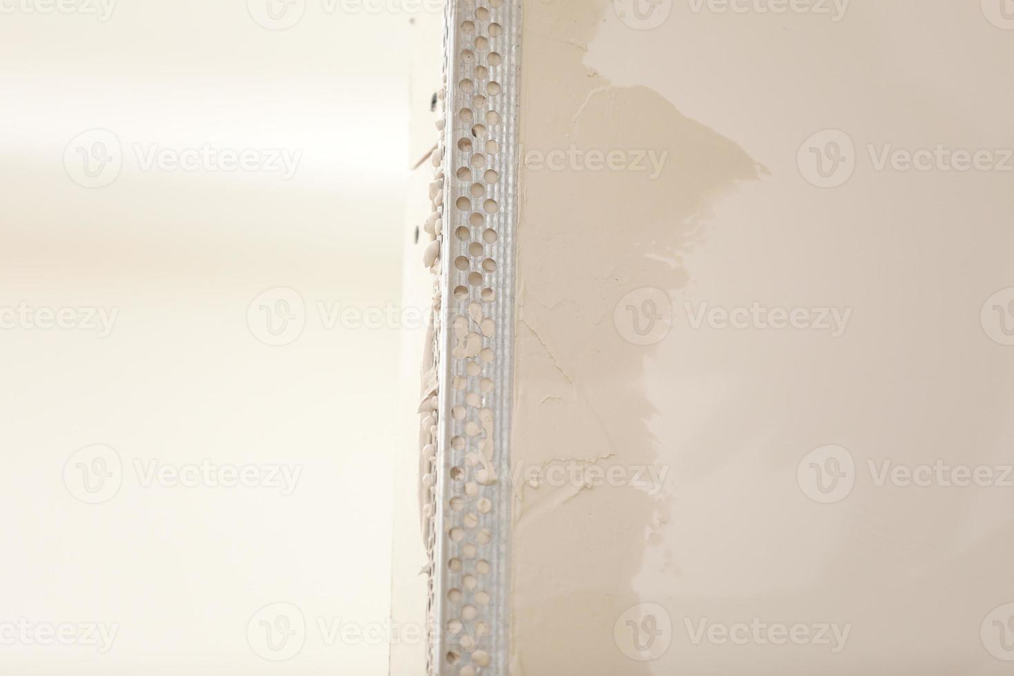 The worker set the metal wall profile in the new flat. Plasterboard metal profiles. Gypsum board installation background. Metallic material for building walls photo