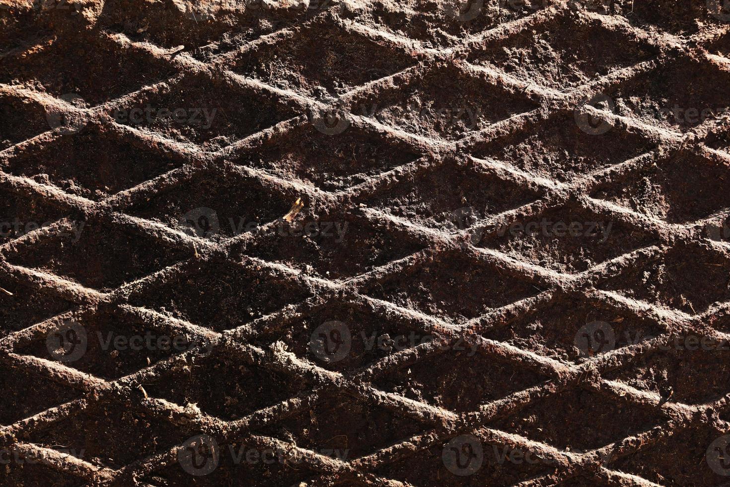 Canal cover surface texture. Rusty iron square pattern. Rusty metal square texture. Robust old iron rusted canal cover wallpaper. Ruststained canal grid form cover backdrop. photo