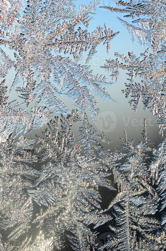 Snowflakes frost rime macro on window glass pane photo