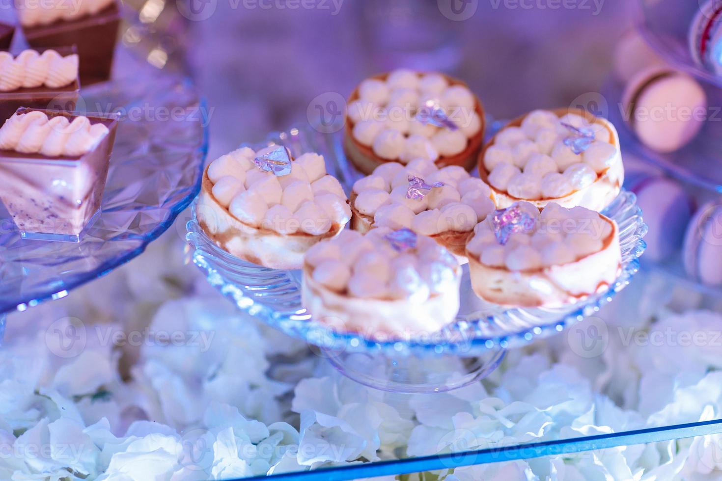Candy bar on wedding ceremony with a lot of different cupcakes, modern desserts, mousses and jellies. selective focus photo