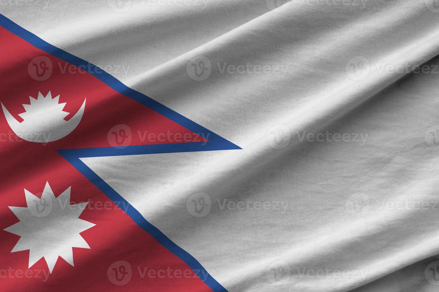 Nepal flag with big folds waving close up under the studio light indoors. The official symbols and colors in banner photo