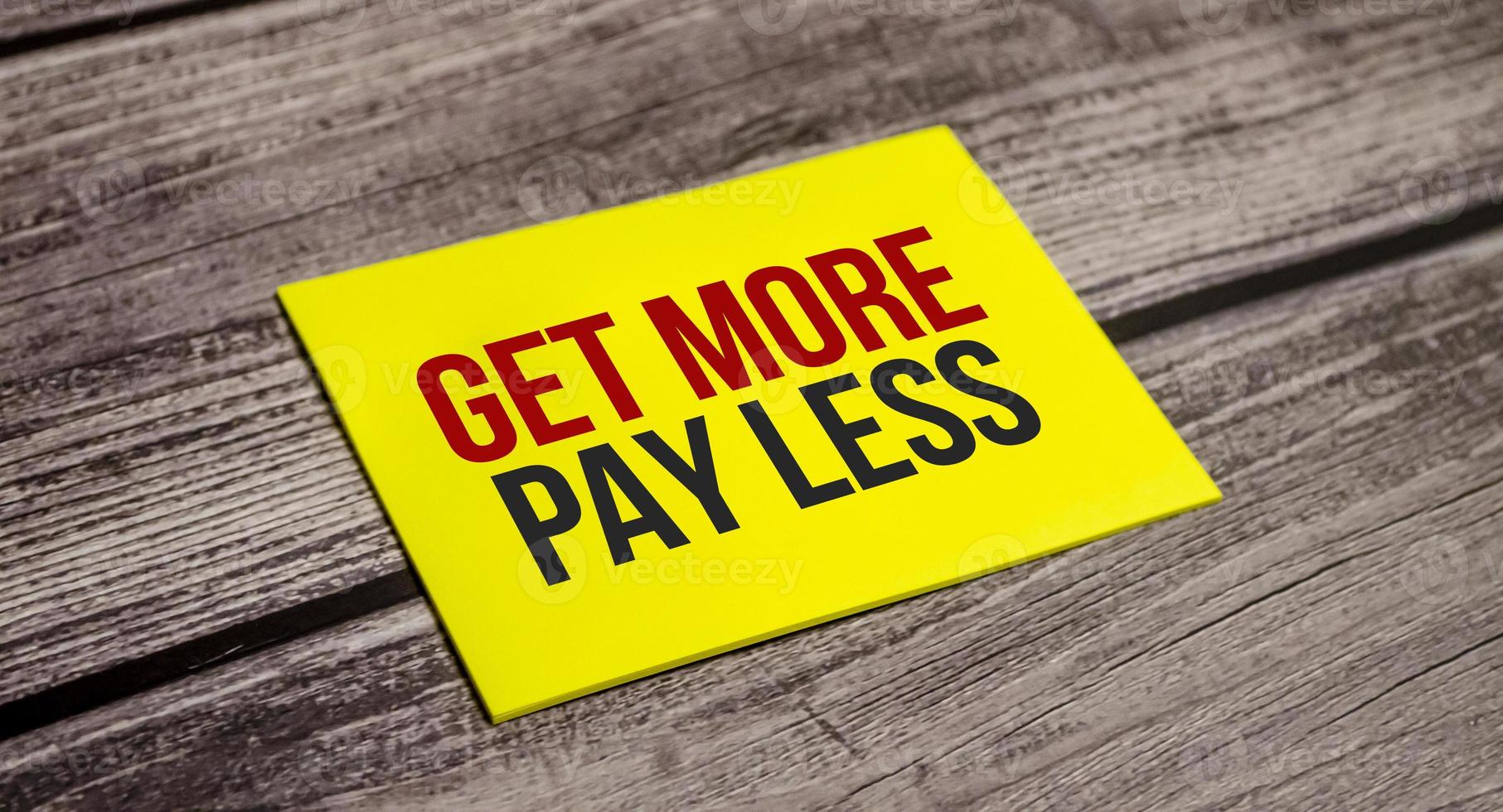 get more pay less Text on business paper on office table photo