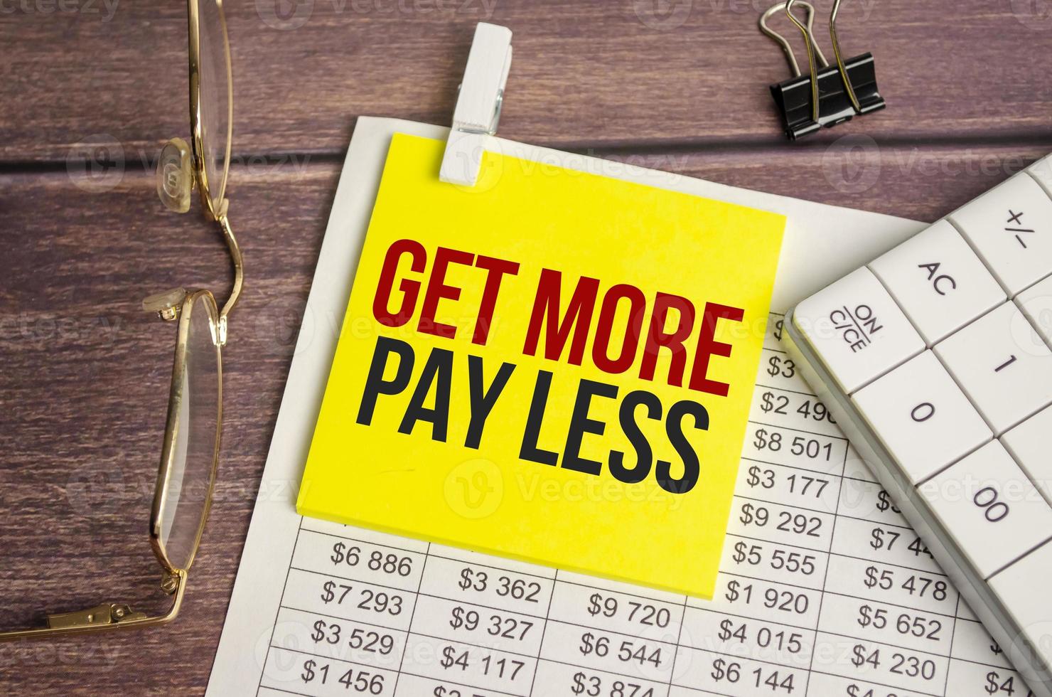get more pay less Text on business paper on office table photo