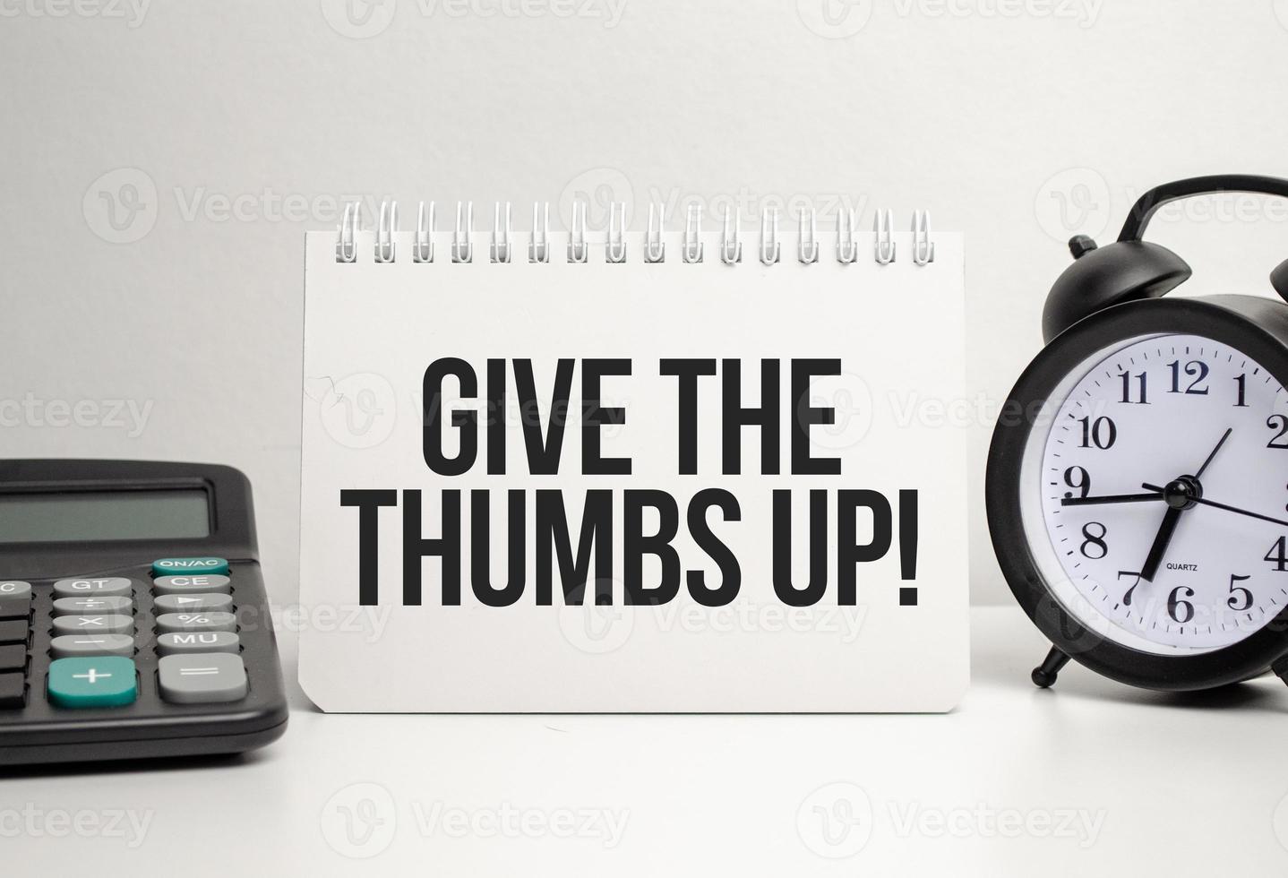 give the thumbs up words with calculator and clock with notebook photo
