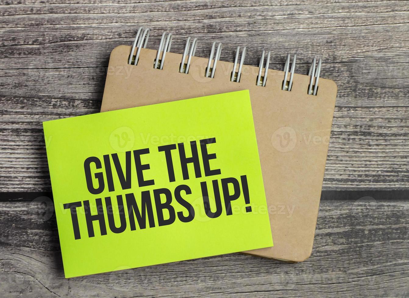 give the thumbs up. Text on green business card with pen photo