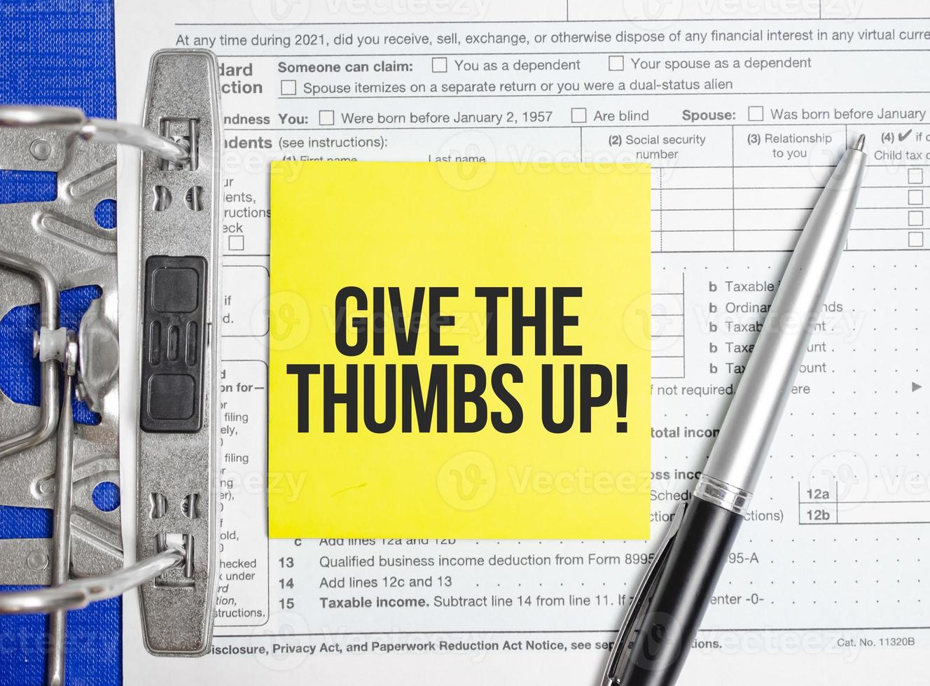 give the thumbs up words on paper notebook with pen photo